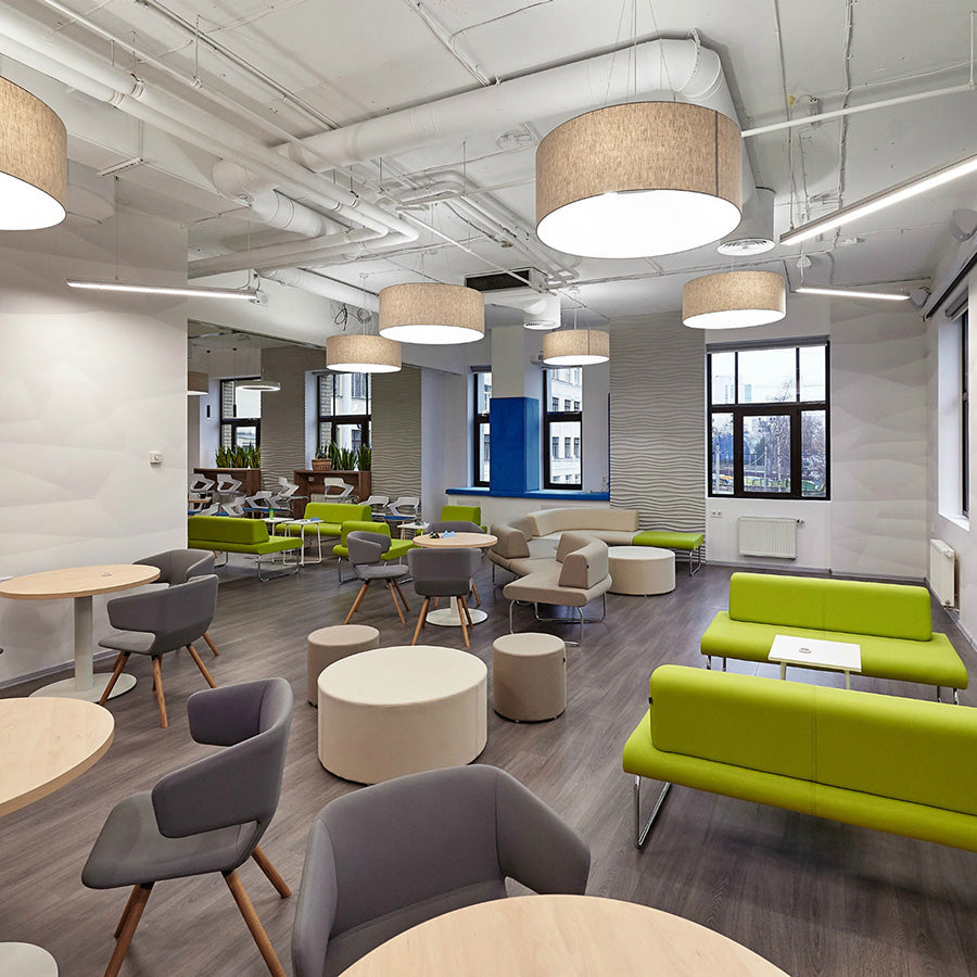 Modern office space with green sofas, gray chairs, round tables and Point Ottomans.