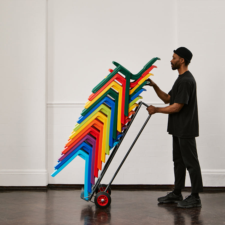 Postura+ Chair Trolley with stacked Postura+ Chairs angled and being pushed